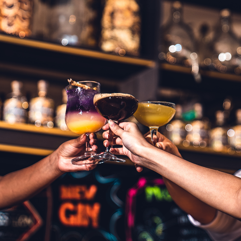 Guests toasting with vibrant Brass Lion cocktails at the tasting room bar.
