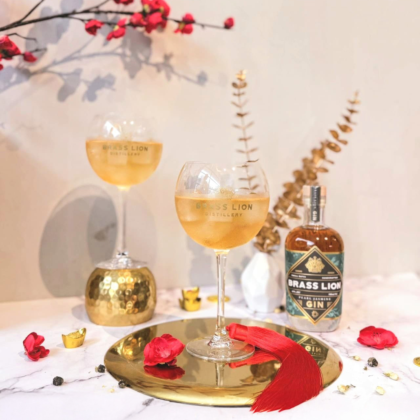 Brass Lion Pearl Jasmine Gin with tonic served in balloon glasses alongside the bottle
