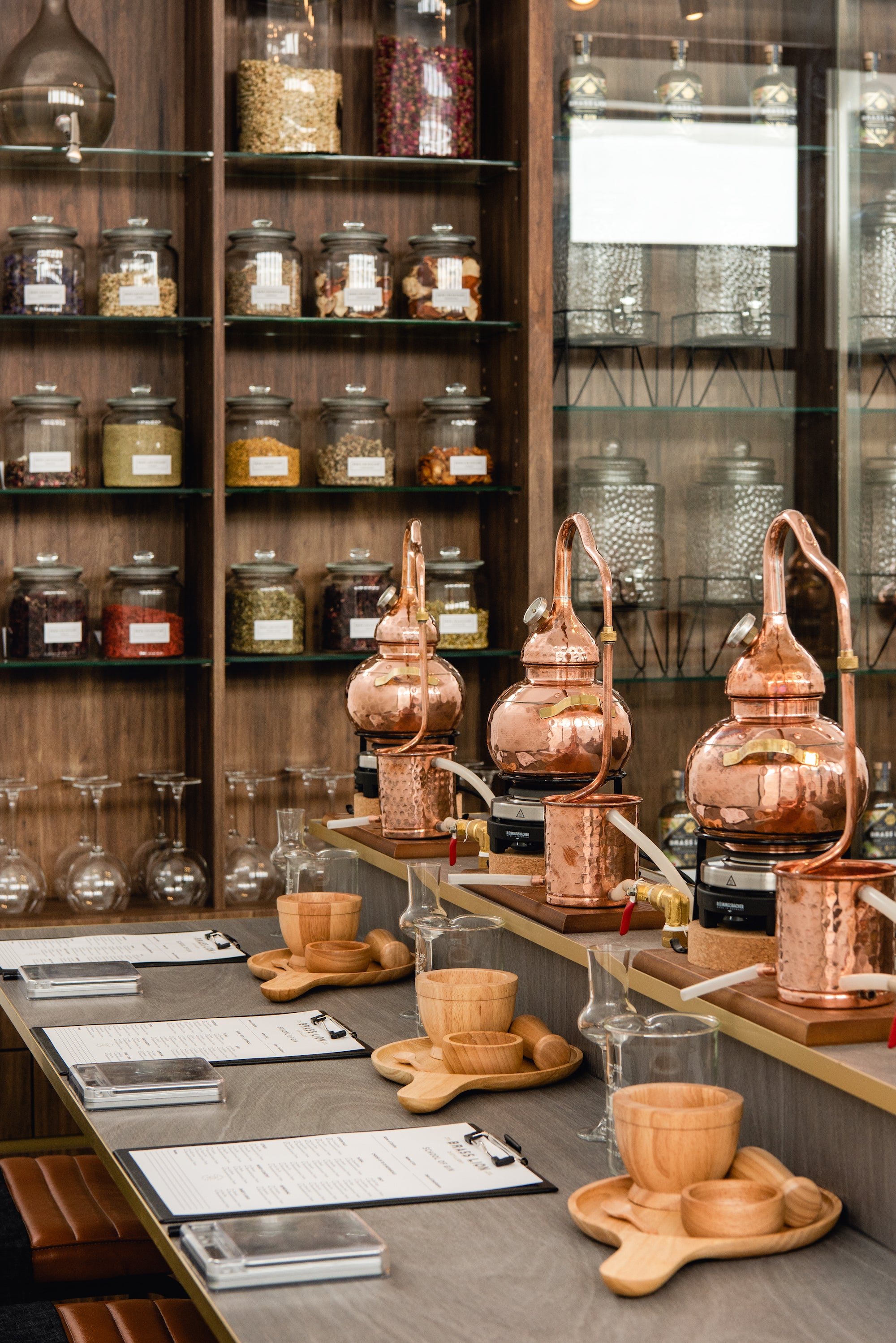 Brass Lion Gin School setup featuring individual copper stills, botanicals, and tasting tools prepared for a hands-on distillation experience