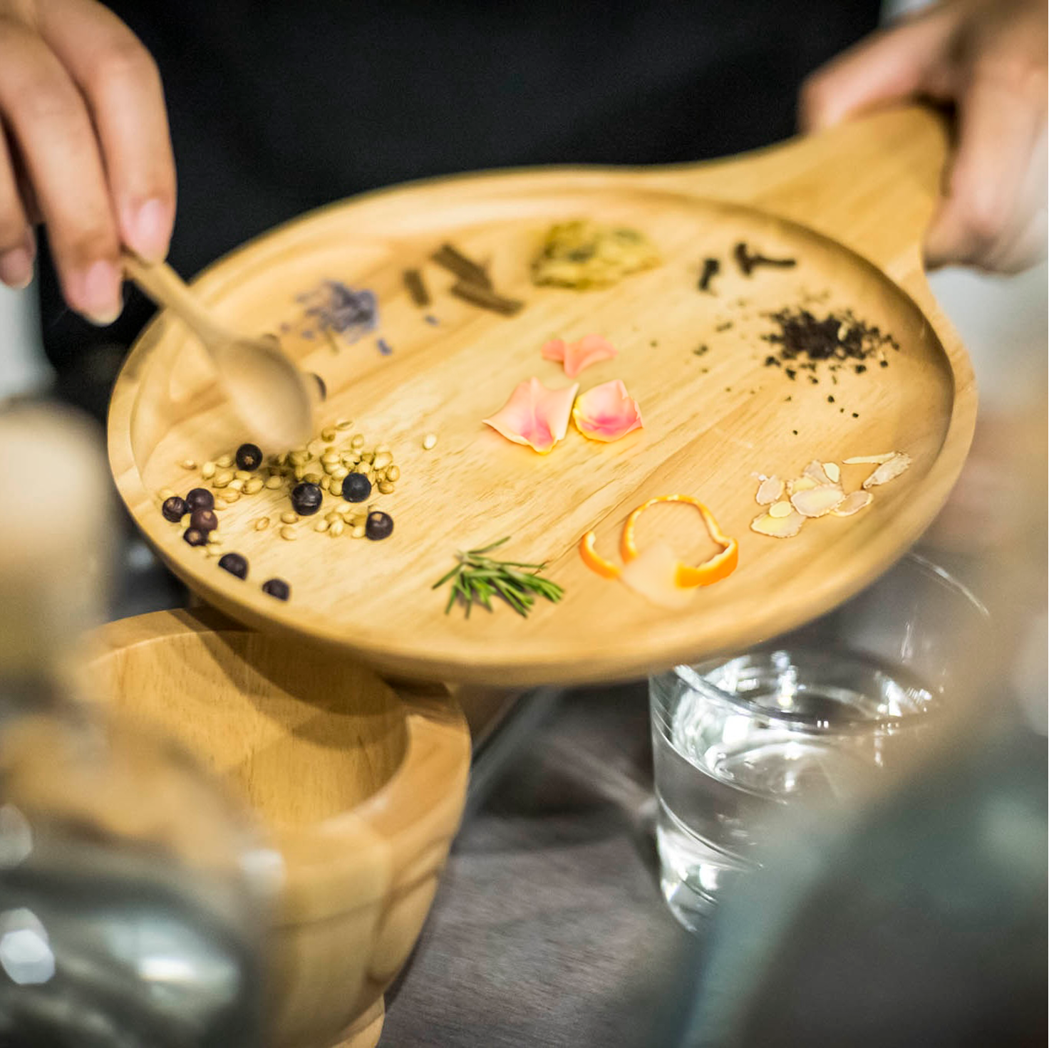 Brass Lion Gin School botanical tray featuring juniper, coriander, citrus peels, and herbs for a personalized gin blending session in Singapore.
